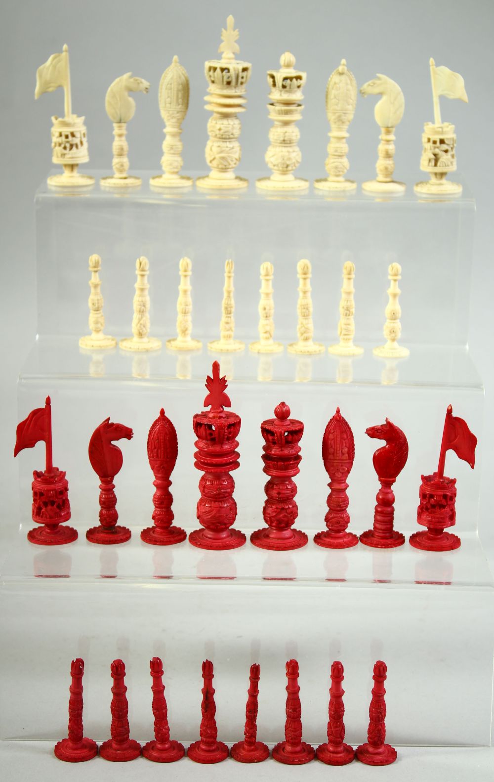 A BURMESE CARVED AND STAINED IVORY CHESS SET, each piece intricately carved, complete, (32 pieces).