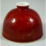 A CHINESE RED GLAZE BRUSH POT, with roundels of incised decoration under glaze, the base with six