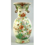 A JAPANESE TWIN HANDLE PORCELAIN VASE, painted with flowers and gilt highlights, 38.5cm high.