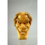 A JAPANESE CARVED IVORY NOH MASK NETSUKE, signed to the reverse, 4.5cm.