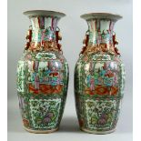 A PAIR OF CHINESE CANTON FAMILLE ROSE PORCELAIN VASES, the body of each painted with panels of