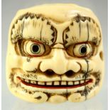A JAPANESE CARVED IVORY DOUBLE SIDED NOH MASK NETSUKE, signed to the base, 4cm wide.