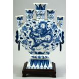 A CONTEMPORARY CHINESE BLUE AND WHITE PORCELAIN TULIP VASE AND STAND, central painted with a dragon,