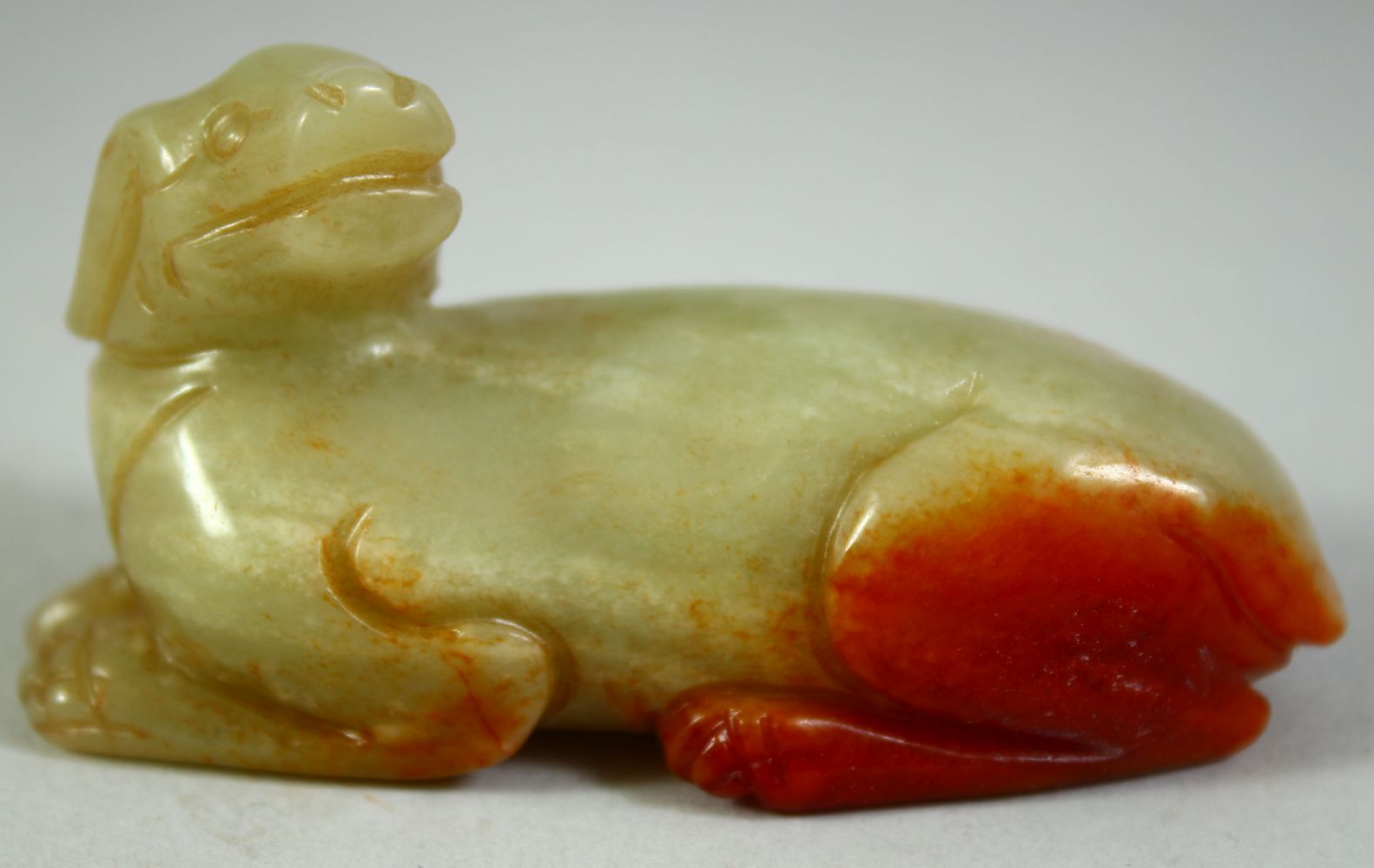 A CHINESE CARVED JADE MODEL OF A RECUMBENT BEAST, 6.5cm long.