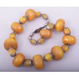 A PRESSED AMBER / BAKELITE LARGE ROUNDEL BEADED NECKLACE, with white metal mounts.