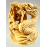 A JAPANESE CARVED IVORY NETSUKE OF A DRAGON, signed to base, 4.5cm high.