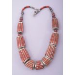 A NEPALI CORAL AND WHITE METAL NECKLACE.