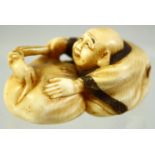 A JAPANESE CARVED IVORY NETSUKE of a seated man playfully teasing a mouse in a basket, signed to the