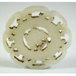 A 19TH CENTURY CHINESE CARVED AND PIERCED JADE AMULET, of circular form - the centre carved with a