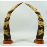 A PAIR OF CHINESE CARVED BULL HORNS mounted to wooden bases, each carved with a dragon with onlaid