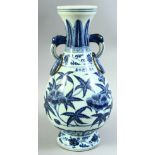 A CHINESE BLUE AND WHITE TWIN HANDLE PORCELAIN VASE, the body painted with native flora, the two