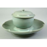 A CHINESE RU STYLE CELADON TEACUP, COVER AND SAUCER, saucer diameter 18.5cm.