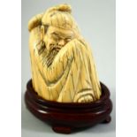 A CHINESE CARVED MAMMOTH IVORY FIGURE of a crouching sage, on a fitted hardwood base, figure 7.5cm