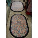 A floral decorated rug and matching larger rug.