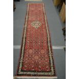 A Persian style red ground runner.
