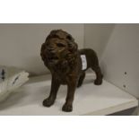 A cast metal model of a lion.