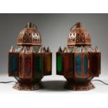 A PAIR OF NORTH AFRICAN METAL OCTAGONAL LANTERN with coloured glass panels. 14ins high.