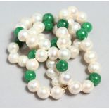 A STRING OF PEARLS with jade beads and gold clasp.