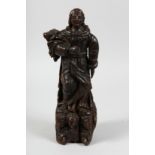 A 17TH CENTURY, POSSIBLY ITALIAN CARVED SAINT on an angel carved base. 15ins.