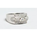 AN 18CT WHITE GOLD AND DIAMOND RING with a central single stone flanked by small diamond clusters