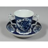 A BOW CHOCOLATE CUP AND SAUCER, the cup of flared beaker shape with two ornately moulded handles,