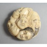 A MANY FACED BONE NETSUKE, 1.25ins diameter.