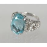 A LARGE AQUAMARINE RING with diamond shoulders.