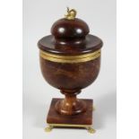 A REGENCY STAINED ALABASTER URN AND COVER with hinged lid on claw feet.