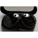 A PAIR OF PORSCHE SUNGLASSES in a case.