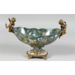 A CONTINENTAL PORCELAIN OVAL PEDESTAL BOWL with bronze cupids. 11ins long.