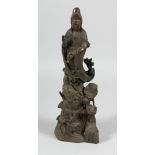 A CHINESE BRONZE TALL FIGURE OF GUANYIN on a lotus base. 14ins high.
