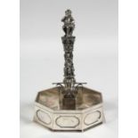 A 19TH CENTURY PLATED RING STAND as a column with garlands and figures with octagonal base. 8ins