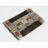 AN ISLAMIC SILVER COMB set with coloured stones, 9cm long x 7cm wide.