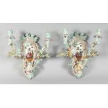 A GOOD PAIR OF MEISSEN PORCELAIN TWO BRANCH WALL SCONCES enamelled with flowers and cupids. Cross