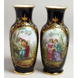 A GOOD PAIR OF SEVRES DARK BLUE PORCELAIN VASES edged in gilt and painted with young ladies. 15ins
