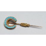 AN 18CT GOLD, TURQUOISE AND SEED PEARL HORSESHOE TIE PIN.