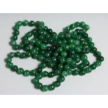 A STRING OF JADE BEADS 52ins long.