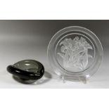 A DANISH SMOKED GLASS ASHTRAY. Signed. 5.5ins and a FLORAL PLATE. Signed. 8ins diameter (2).