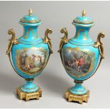 A SUPERB PAIR OF 19TH CENTURY SEVRES PALE BLUE, TWO HANDLED URNS AND COVERS, painted with reverse