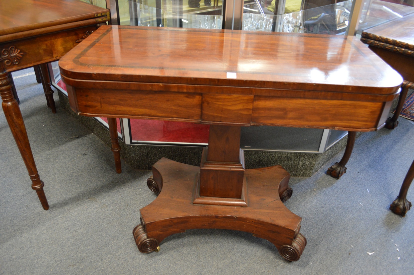 A 19th century mahogany D-shaped foldover card table on pedestal base.