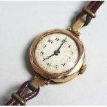 A LADIES 9CT GOLD WRISTWATCH with leather strap.