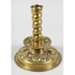 A GOOD EARLY FLEMISH BRASS REPOUSSE CANDLESTICK on a circular base. 8ins high.