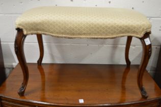 A good upholstered footstool of serpentine outline on carved walnut cabriole legs.