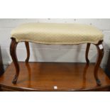 A good upholstered footstool of serpentine outline on carved walnut cabriole legs.