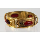 A VICTORIAN GOLD PLATED FLEXIBLE BRACELET set with red stones.
