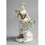 A BOW FIGURE OF A GIRL with flowers standing beside a sheep.