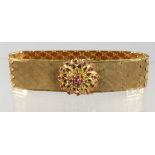 A GOOD WIDE FLEXIBLE GOLD BRACELET with ruby clasp.