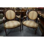 A pair of French style carved mahogany framed open armchairs.