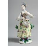A BOW FIGURE OF A GIRL with flowers in her apron.