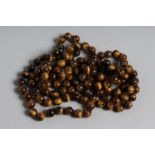 A LONG STRING OF TIGER'S EYE BEADS 46ins long.